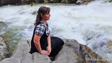 美女坐在石头上，看着滚<strong>烫</strong>的山河水，然后转向相<strong>机</strong>